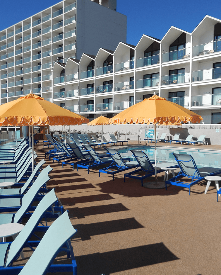 Poolside blue mesh lounge chairs with tangerine-colored standing shade umbrellas