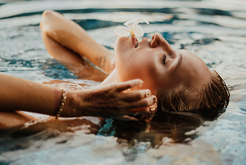 Woman with gold bracelet emerging from water