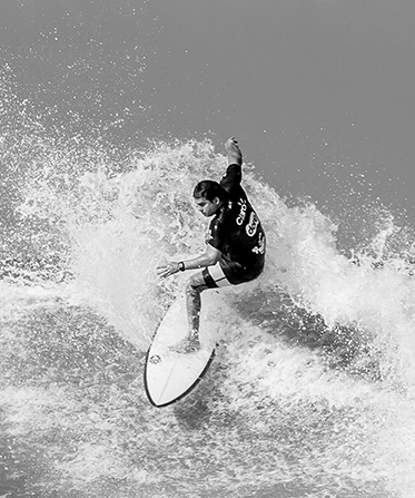 Black and white surfer turning at top of wave